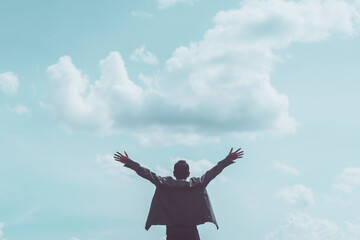 Copy space of man rising hands on blue sky white clouds abstract background. Freedom feel good and...