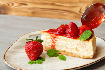 Piece of homemade strawberry cheesecake on white plate