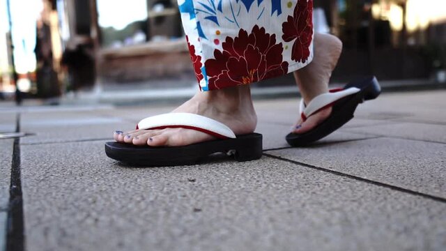 浴衣を着て歩く女性の足元