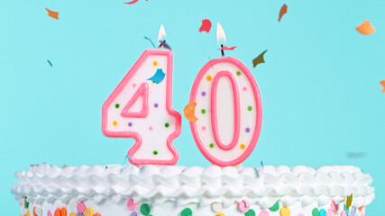 Colorful tasty birthday cake with candles shaped like the number 40. Pastel blue background.