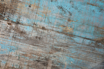 Old wood texture with blue paint and deep cuts .
