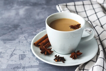 Masala tea in white ceramic cup with spices