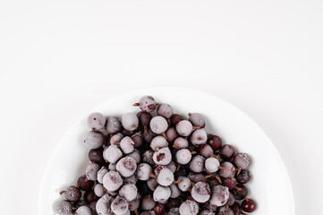 Plate of refreshing frozen gooseberries covered in frosting for a delicious healthy dessert