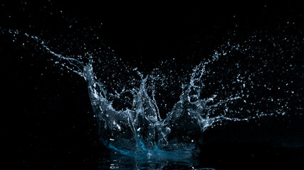Naklejka na ściany i meble Freeze motion of water splash isolated on black background.