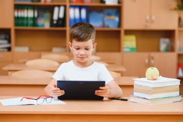 Fototapeta na wymiar school boy using tablet compute in classroom