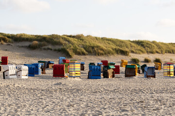 Colorful roofed wicker beach chairs on a sandy beach on the North Sea coast 