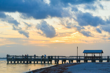Obraz premium sunset at Sanibel lighthouse park where people are fishing on a dock