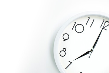 A wall clock that announces 7 o'clock on the hour