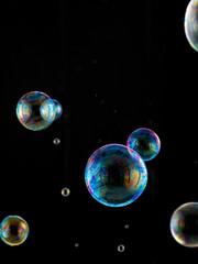 Obraz na płótnie Canvas colored soap bubbles on black background
