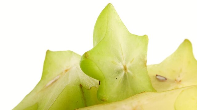 4K Organic star fruit carambola or star apple ( starfruit ) close-up rotates on a white background