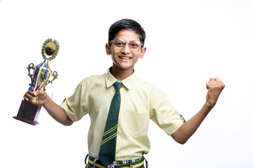 Clever schoolboy raising his trophy as a winner in school competition.