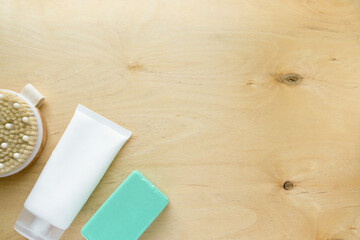 Soap, shampoo and massage brush on wooden background. Space for text