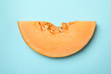 Melon slice on blue background, close up