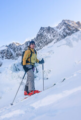 Fototapeta na wymiar Junge Extremsportlerin steilen Aufstieg mit Skiern im vergletscherten Hochgebirge