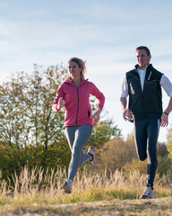 Junges, sportliches Paar joggt an einem herbstlichen Nachmittag