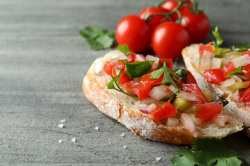 Delicious bruschetta snacks on gray textured background