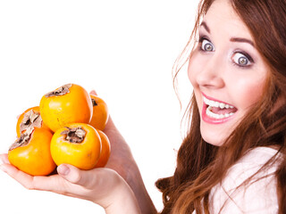 Cheerful woman holds persimmon kaki fruits, isolated