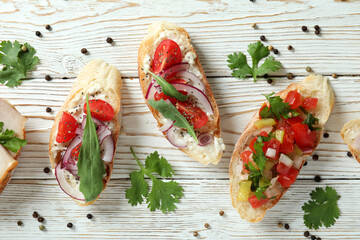 Delicious italian snacks bruschetta on white wooden background