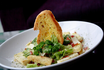 garlic bread with salad and cheese serve in white plate