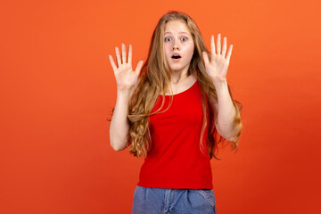 Horizontal portrait of young scared girl isolated on red studio background. Concept of human emotions, facial expression, youth, sales, ad.