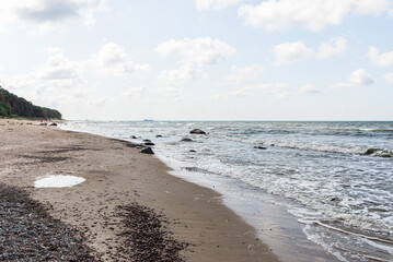 Empty Beautiful sandy beach with a few tourists.Blue sky,clouds.Summer day.