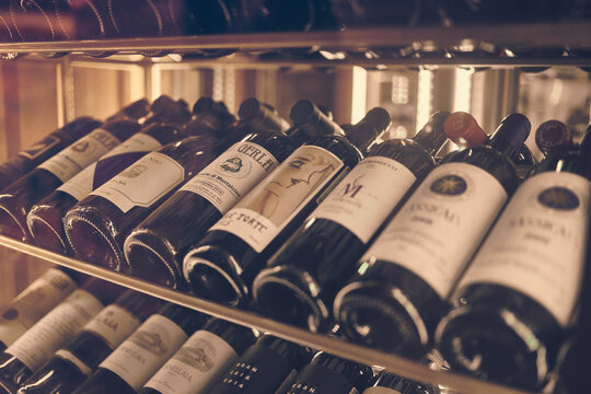 Moscow, Russia - Dec 2019: Mood shot of grand red wines in rack in restaurant. Close up wine bottles.