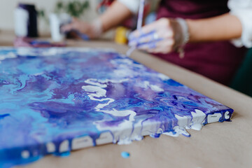 Fototapeta premium Artist mixing acryl paints on the picture working in fluid art technique