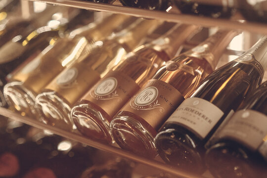 Paris, France - Dec 2019: Mood shot of brut Champagne sparkling wine Louis Roederer Cristal Rose 2009 and other wines in rack in restaurant. Close up wine bottles. Wine par excellence with a finesse.