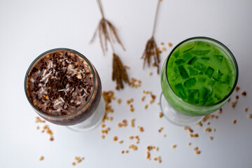 Green and brown cincau, indonesian traditional drinking, with chocolate topping and small ice on white table