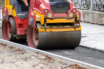 The roller compacts asphalt on a bicycle path. Construction of new roads. Restoration of the road surface.