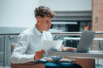 Joven profesional directivo apuesto sentado trabajando con el ordenador de forma profesional
