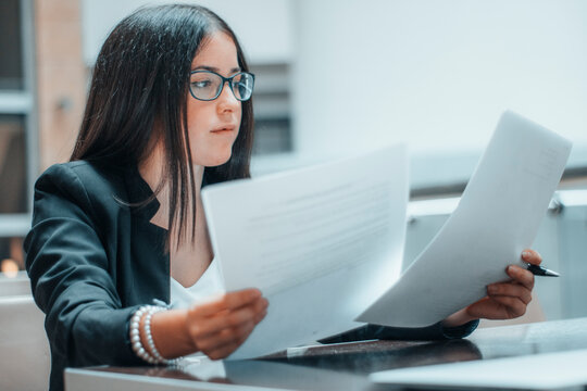 Gestora trabajadora comprueba hojas de trabajo en su bufete