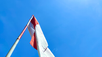 Fototapeta premium Photo of the red and white flag flying on a pole to celebrate Indonesia's independence day