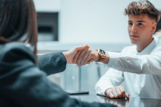 Estech&aacute;ndose la mano trabajando en equipo con una sonrisa
