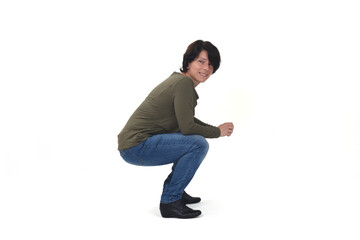 side view of a woman sitting squatting and looking at camera on white background