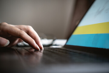 Fototapeta premium Close up view of hand typing on laptop keyboard
