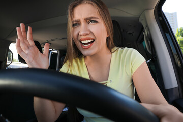 Emotional woman in car. Aggressive driving behavior
