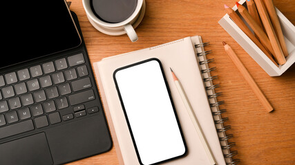 Mockup of smartphone white screen and tablet, office space close up in top view