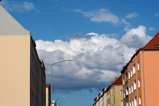a street with houses in a European city in sunny weather with white clouds and blue sky. bottom view