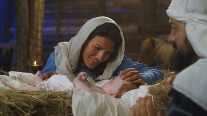 Mary talking with baby Jesus near Joseph