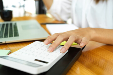Fototapeta na wymiar Close up fingers, woman calculating, using calculator, workspace