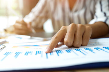 Close up image, business female pointing finger on financial data papers