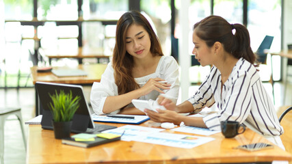 Young business colleague discussing online project, working in office together