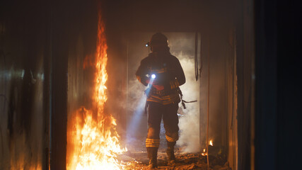 Fireman examining burning corridor during rescue mission