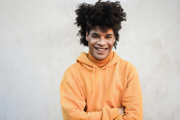 Young mixed race man smiling on camera outdoor in the city - Focus on face