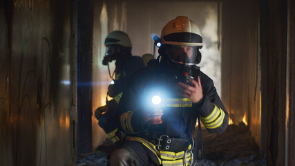 Firemen examining hallway after fire