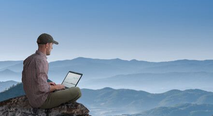 man working remotely outdoors with laptop