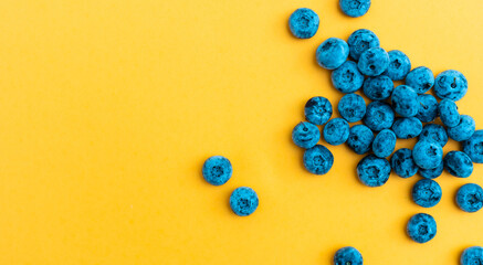 Colorful fruit pattern of blueberries on yellow background. Top view. Flat lay