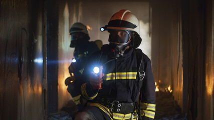 Firemen examining hallway after fire - obrazy, fototapety, plakaty