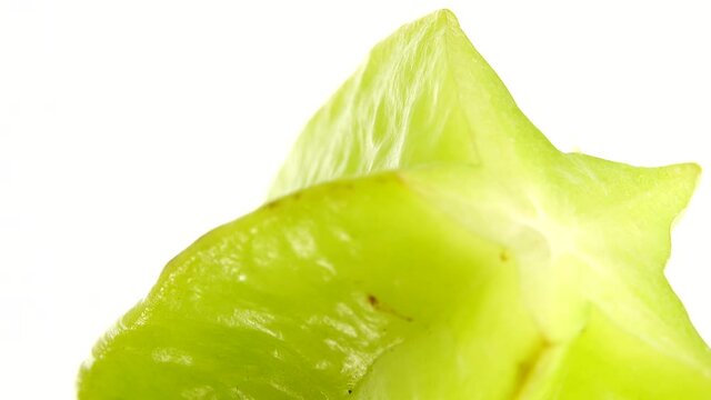 4K Organic star fruit carambola or star apple ( starfruit ) close-up rotates on a white background